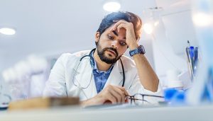 tired doctor sitting at a desk