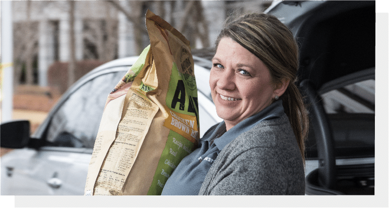 woman holding a sack of dog food