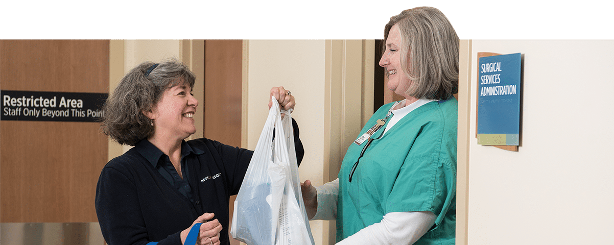 nurse handing a patient a plastic bag of personal items