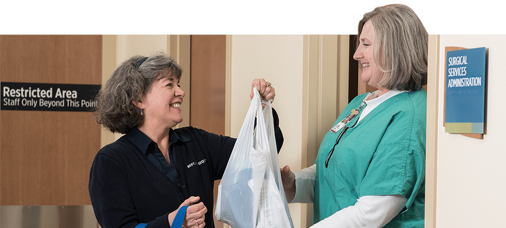 nurse handing a patient a plastic bag of personal items