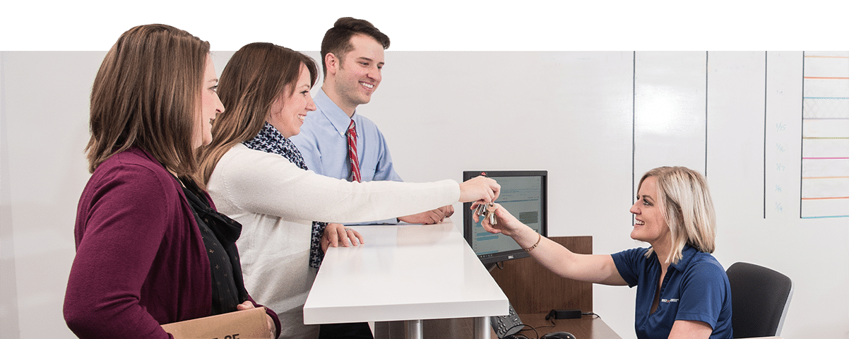 people standing around reception desk in an office