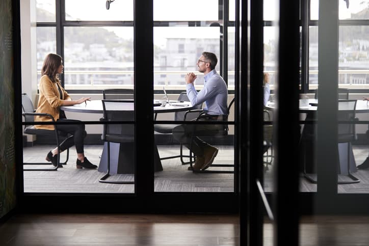 Manager conducting a stay interview with employee in a private office.