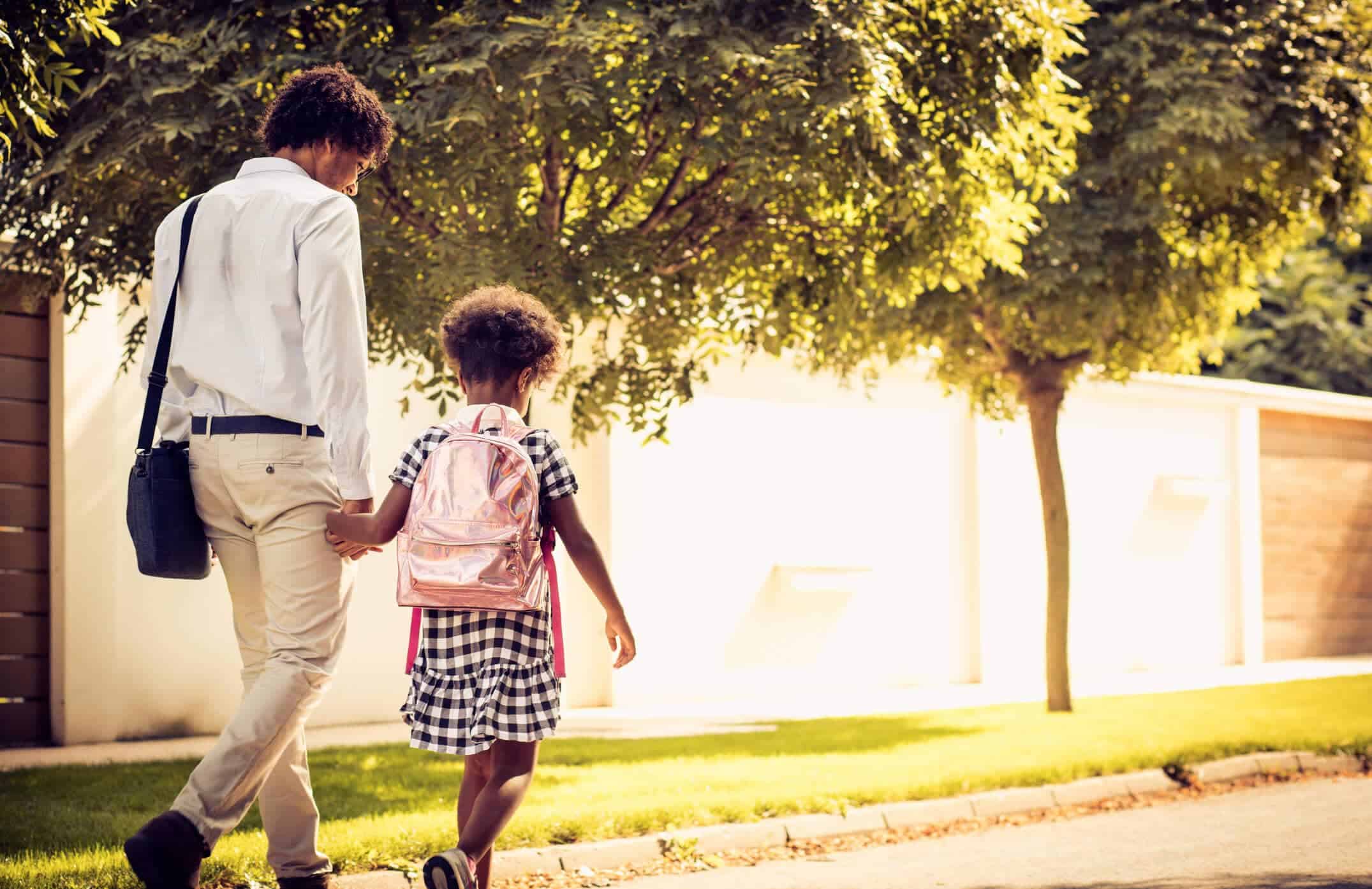 Blog header image: A business man walks his young daughter to work on the first day of school.